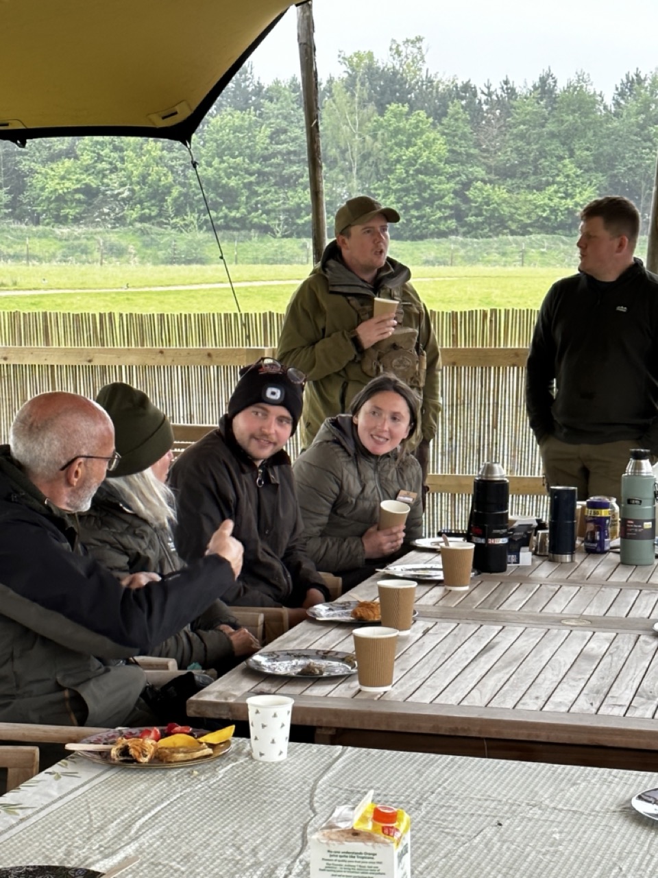 People sitting outside in a stretch tent erasting breakfast