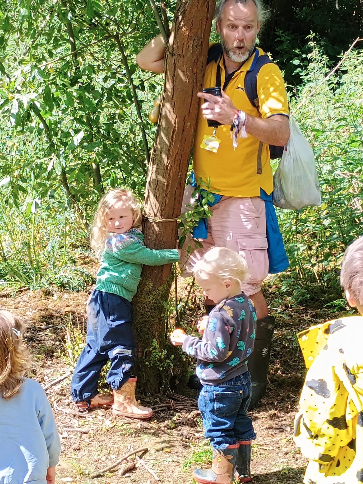 Children and an outdoor educator under trees in a wood<br />
