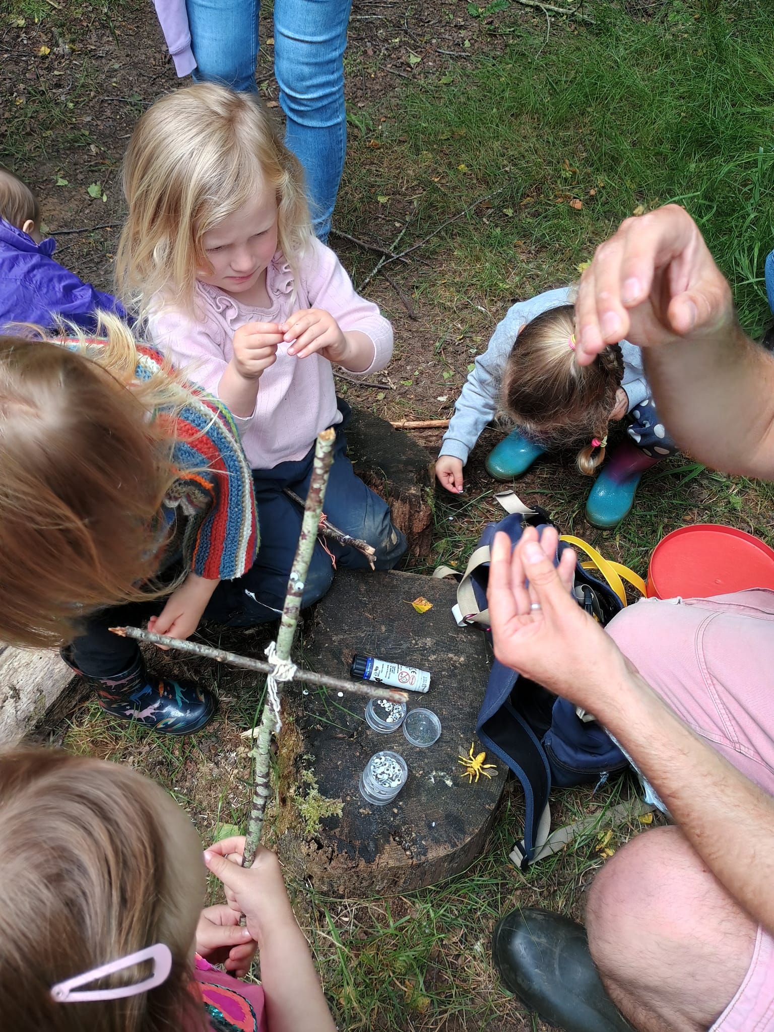 Children making wooden crosses with woodland materials