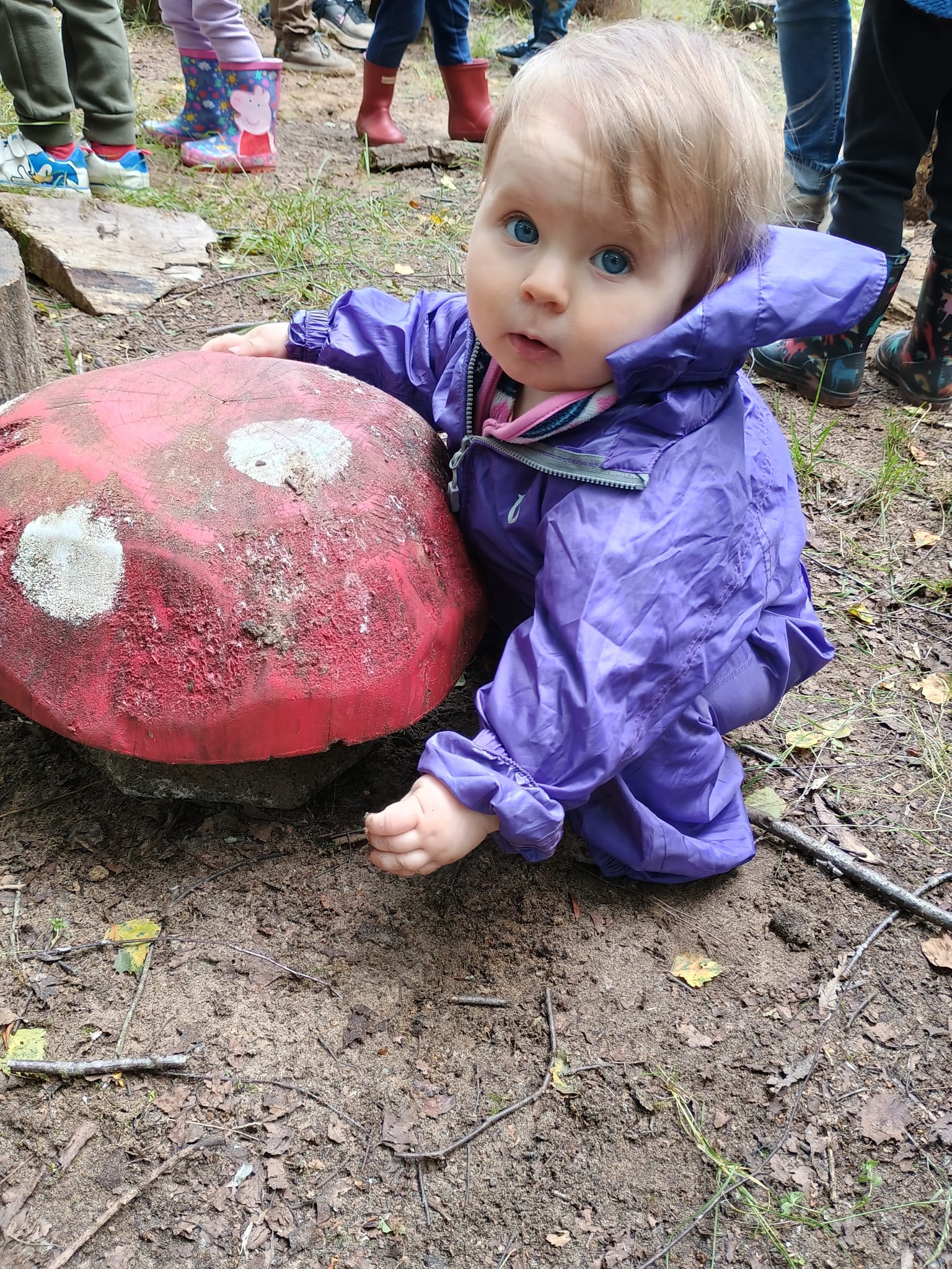 A little girl on a wooden mushroom